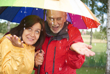 Senior couple playing with rain 