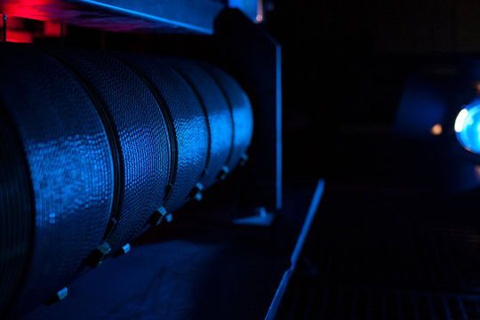 Blau beleuchtete Seilwinde mit Drahtseil auf einem Schnürboden - Blue illuminated cable winch with wire rope on a laced floor 