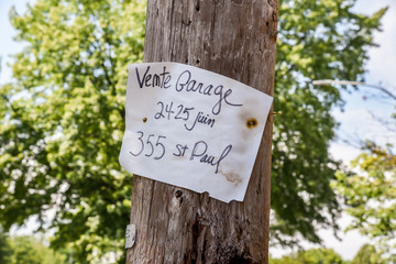 french garage sale sign on wood utility pole in Quebec
