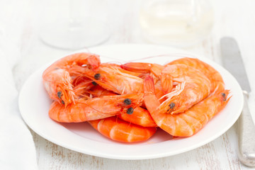 boiled shrimps on white dish on wooden background