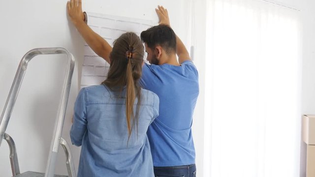 cheerful and happy young couple renovating and painting new home