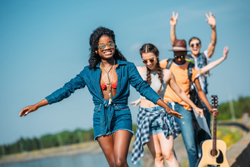 multiethnic happy young friends in casual clothing looking at camera