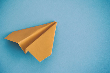 Yellow paper plane on a blue background