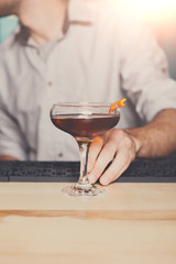 Bartender offers alcoholic cocktail in bar