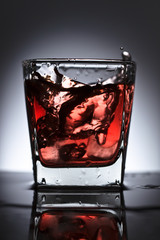 Glass of whiskey with ice on a black background
