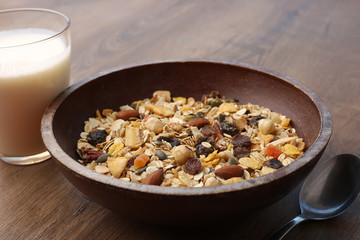 Muesli with nuts and tropical dried fruits. Healthy breakfast: flakes cereal in wooden plate.