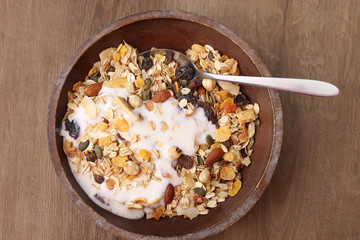 Muesli with nuts and tropical dried fruits. Healthy breakfast: flakes cereal in wooden plate.