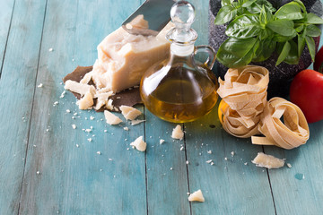 Italian and Mediterranean food ingredients on old wooden background pasta,olive oil, basil ,cheese,and mortar. for pesto or pasta recipe