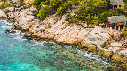 Rocky south costline of Koh Tao Islands with bungalows on granite rocks. Thailand