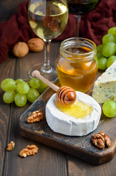 Variety of cheese with grapes, walnuts and wine, selective focus
