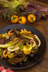 Fresh mix salad with shrimps, yellow cherry tomatoes and balsamic sauce. on wooden background. Close-up. Top view