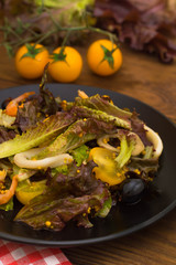 Fresh mix salad with shrimps, yellow cherry tomatoes and balsamic sauce. on wooden background. Close-up. Top view
