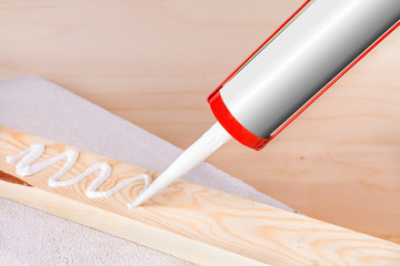 A person will seize a crack with silicone and sealant int the wood 