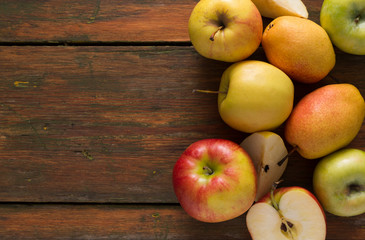 Apples and pears on wooden background