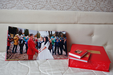 Pages of elegant red wedding photobook or photoalbum on the soft beige background.