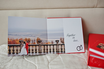 Pages of elegant red wedding photobook or photoalbum on the soft beige background.