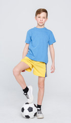 Boy in casual with soccer ball at white studio background