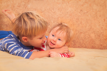 little boy play with little newborn sister at home