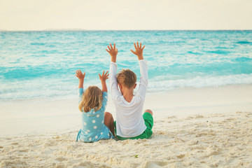 little boy and girl play on summer beach