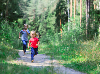 Fototapeta premium happy little girl and boy run play in summer nature