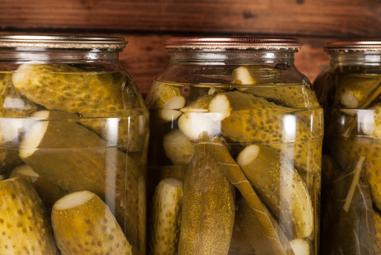 Pickled cucumbers on wooden background. Pickled cucumbers in a jar