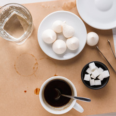 Black coffee cup and treats on craft paper background