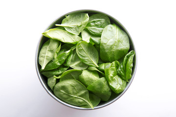 Spinach in a bowl. Healthy green vegetable meal on a white background. Top view