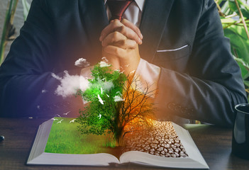 Concept of changes. Open book. One side full of grass with a life tree, different side is desert...