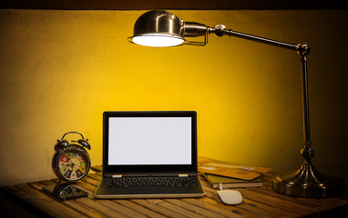 Laptop computer with desk lamp and office equipment.