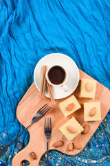Indian dessert halava with almonds served with coffee on indigo cloth copyspace