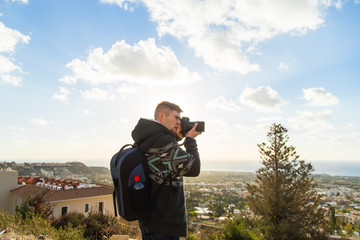 Traveler photographer with digital camera on top of the mountain.