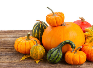 pile of raw orange pumpkins ripe on wooden table border isolated on white background