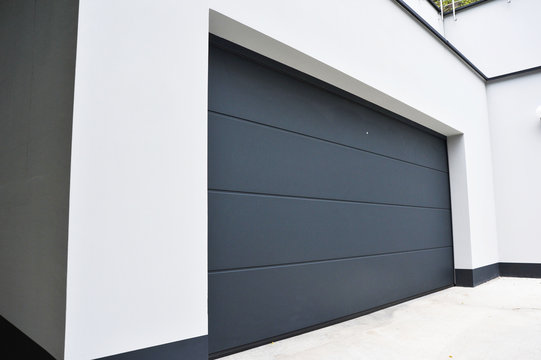 Moderne Einfahrt mit Beton-W&auml;nden und Garage mit Automatik-Tor