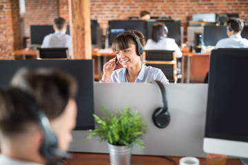 Call center worker accompanied by her team. - obrazy, fototapety, plakaty