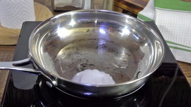 Melting coconut oil in a frying p