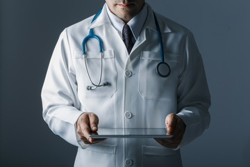 Doctor with stethoscope and tablet computer on black background, still life style, Technology to treat patients concept.