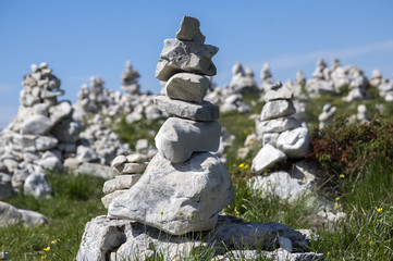 View point with white stone cairns on hiking trail Alta Via del Monte Baldo, ridge way in Garda Mountains