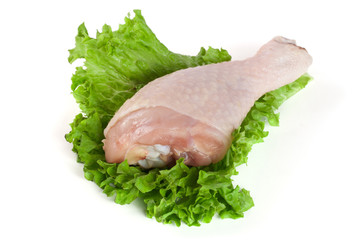 raw chicken drumstick with lettuce leaf isolated on white background