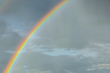 Fototapeta premium Rainbow seen close up at sunset on a cloudy day