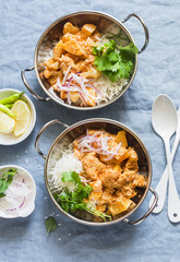 Vegetarian potato and cauliflower curry with rice in curry dishes on a blue background, top view. Vegetarian healthy food concept. Flat lay