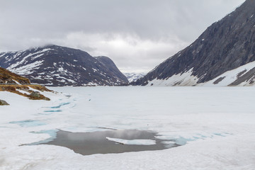 The frozen lake in the Norwegian mountains in the background