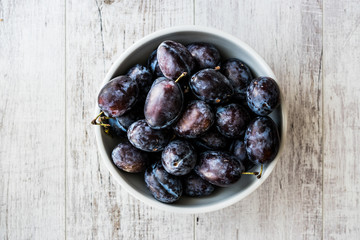 Damson Plum on white wooden surface.
