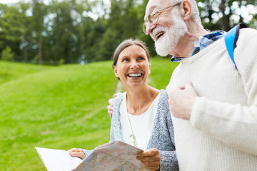 Laughing pensioners with map spending weekend in the countryside