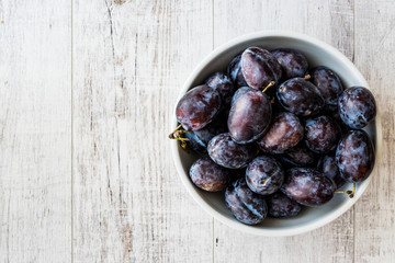 Damson Plum on white wooden surface.
