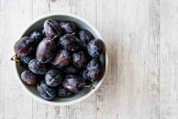 Damson Plum on white wooden surface.