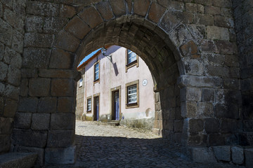 Obraz premium The town's gate and the facade of a colorful house in the historic village of Castelo Mendo in Portugal; Concept for travel in Portugal