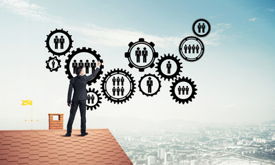 Businessman on house roof presenting teamwork and connection con