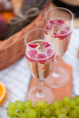 Two glasses of champagne. Picnic on the beach at sunset in the white plaid, food and drink conception