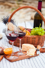Picnic on the beach at sunset in the white plaid, food and drink conception
