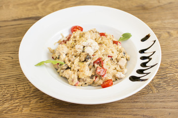Fragrant Pilau/Pulav / pilaf /pilaf, fried rice with meat and vegetables on a white plate. Isolated on a wooden table.